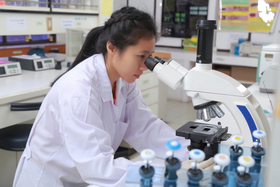 Researcher examining a sample using a light microscope